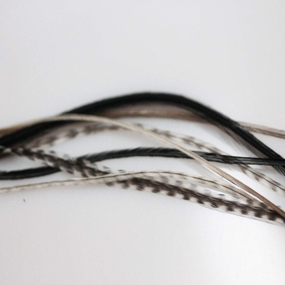 "Enjoy the Salt & Pepper Remix Feather Hair Extension, ranging from 7 to 10 inches in length. These seven feathers are expertly bonded together to create a single extension."